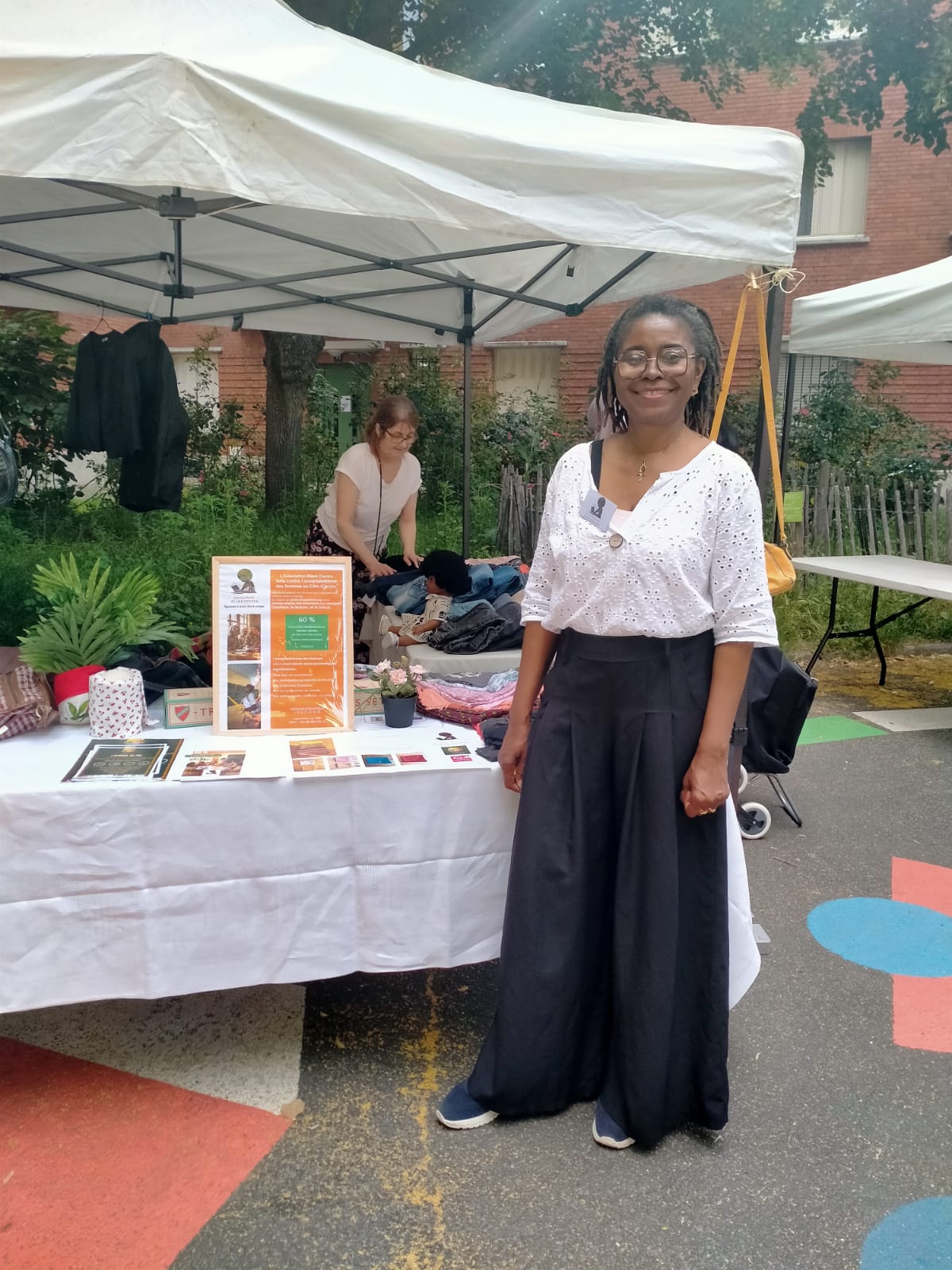 Gros plan sur une bénévole devant le stand d'accueil de Klaré Centre