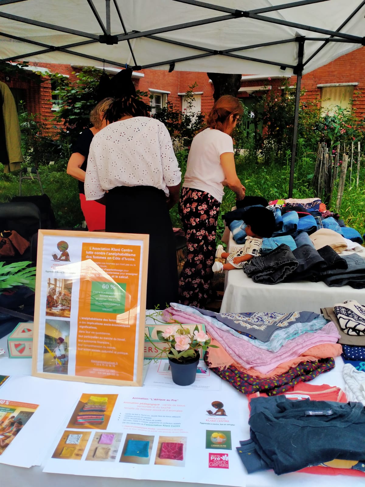 Table de présentation avec des foulards colorés, des brochures, un cadre d'information