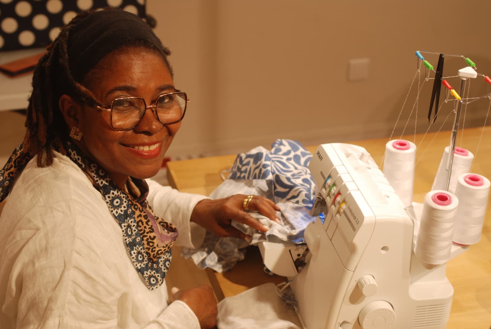Bénévole souriante à la machine à coudre