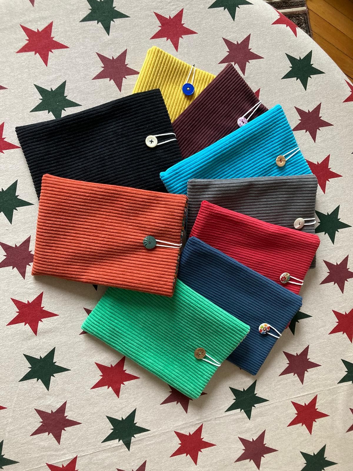 Assortiment de pochettes artisanales en velours côtelé de plusieurs couleurs disposées en étoile