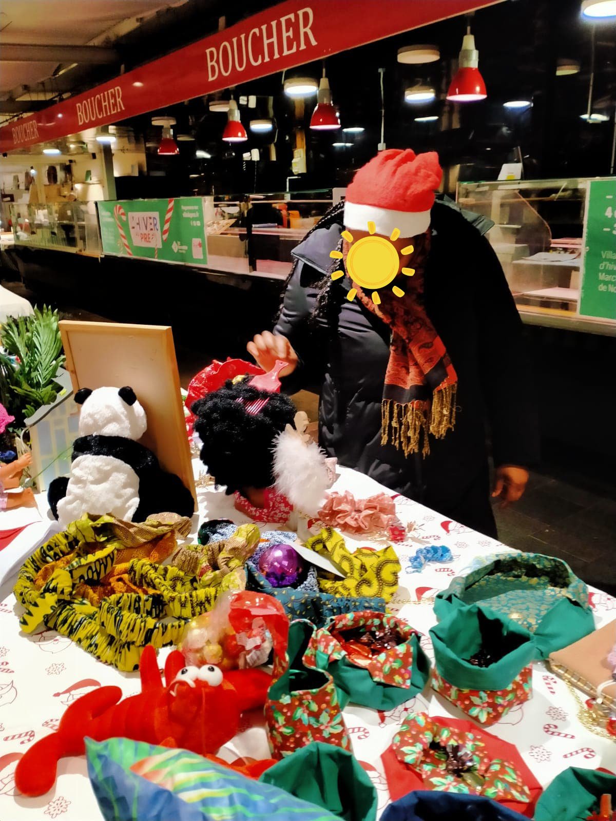 Bénévole en bonnet de Noël devant le stand